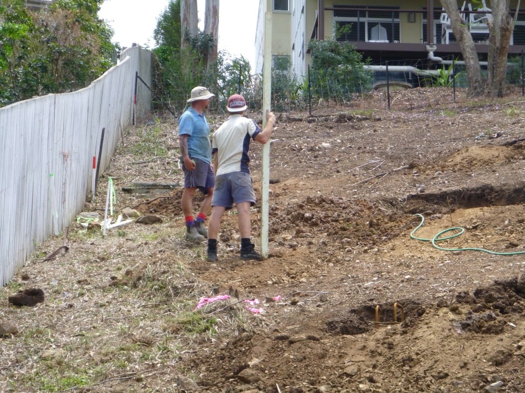 workmen surveying sloping block