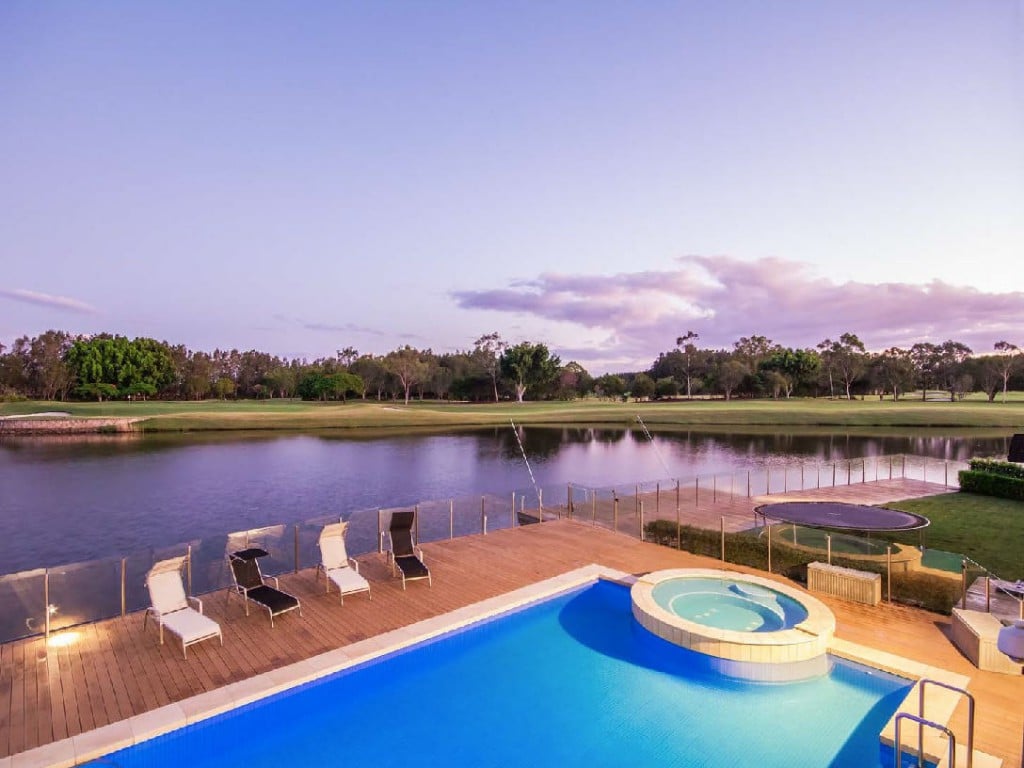 Lap pool and spa overlooking Lakelands Golf Course in this Carrara dream home