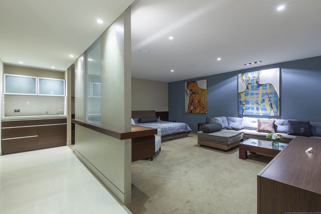 A spacious modern bedroom with lounge suite